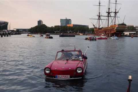 100 amphibious cars glide through Amsterdam's canals on a final float for a while